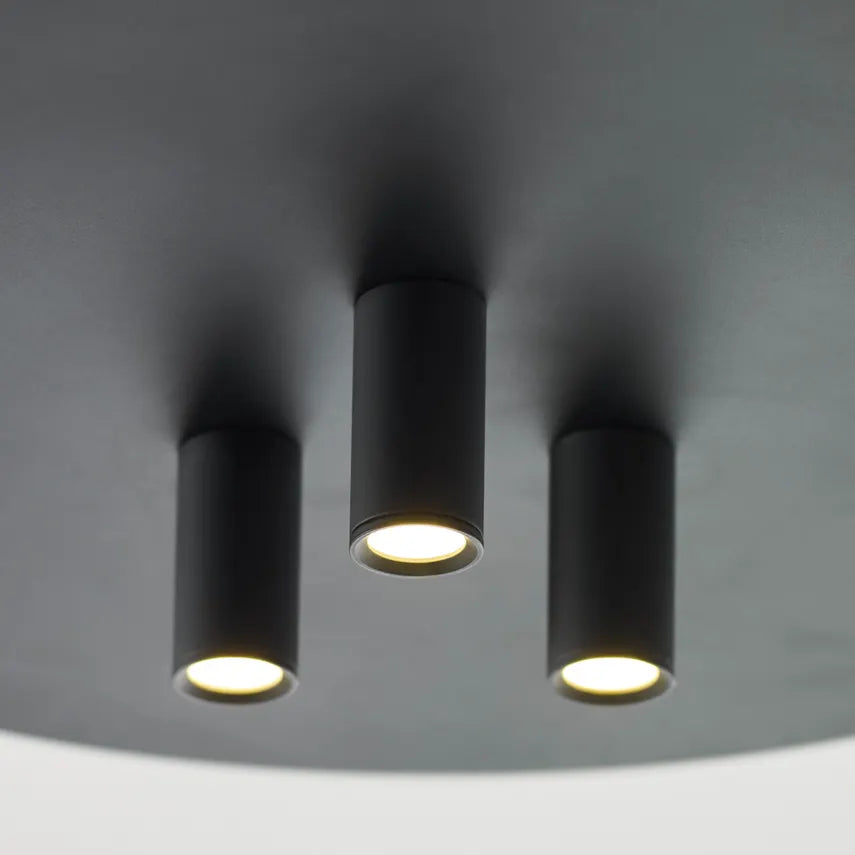 Three black light fixtures on a dark ceiling.