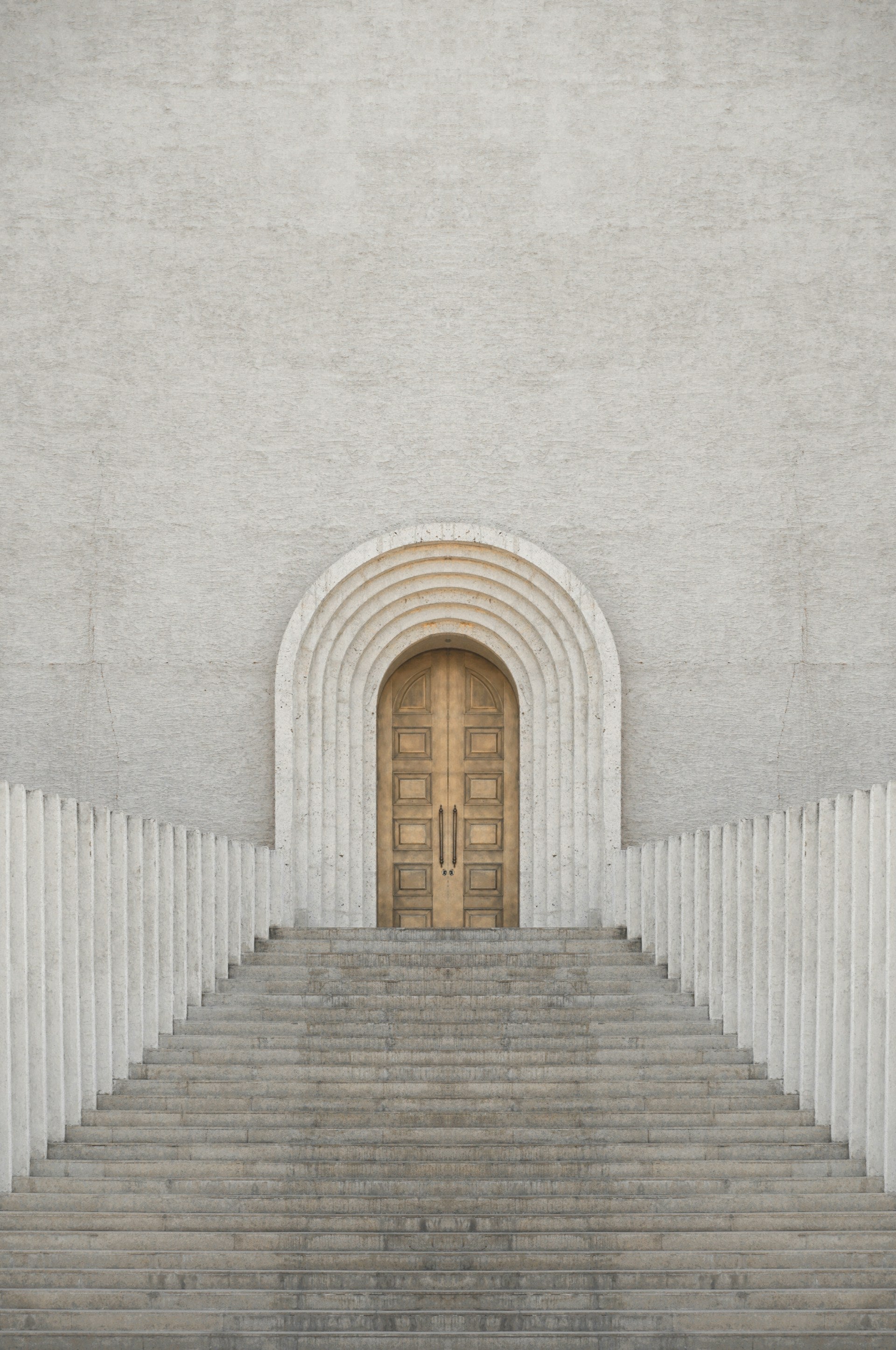 A white building with a wooden door and steps leading up to it.