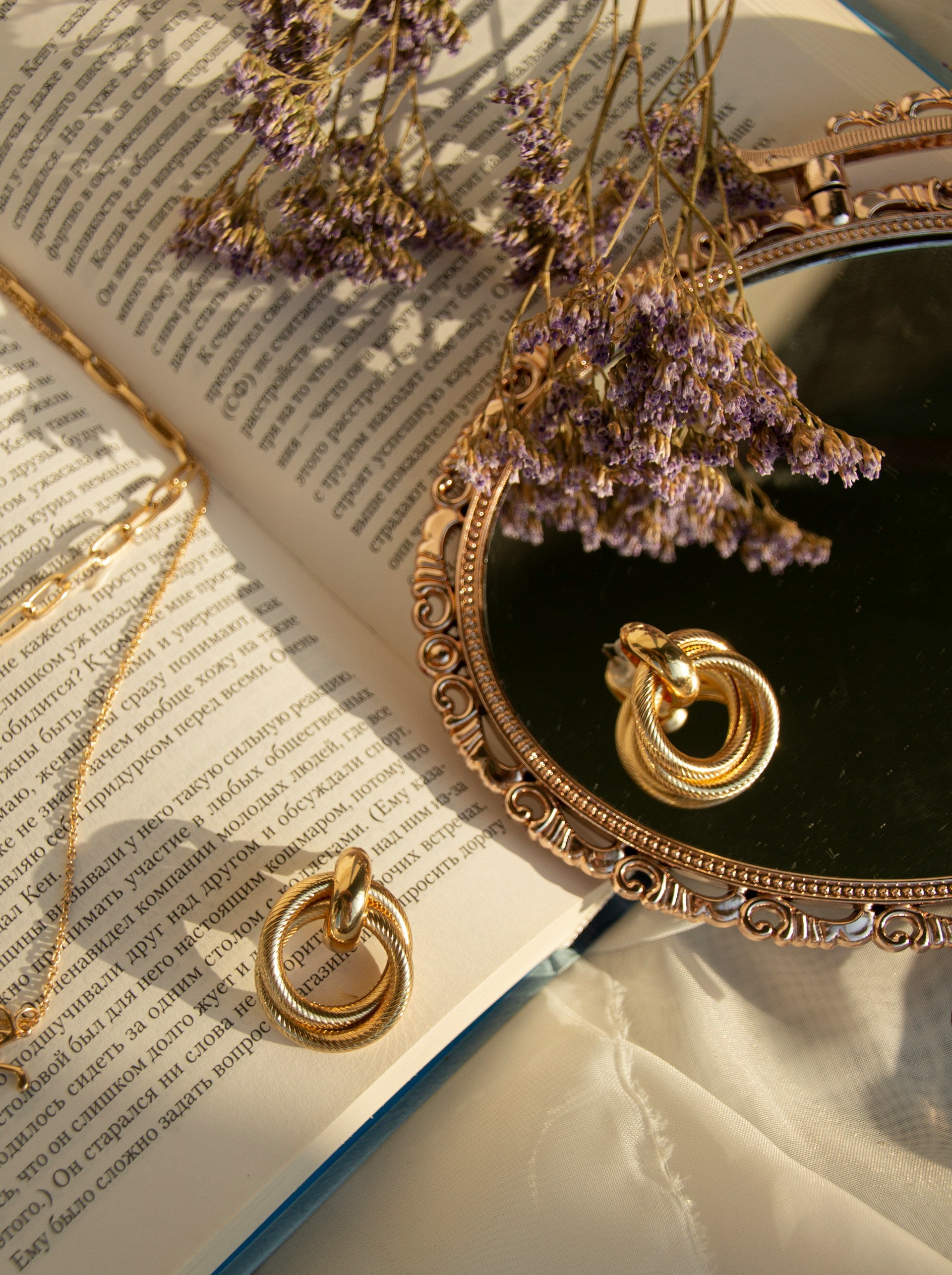 A book with a mirror, and jewelry.