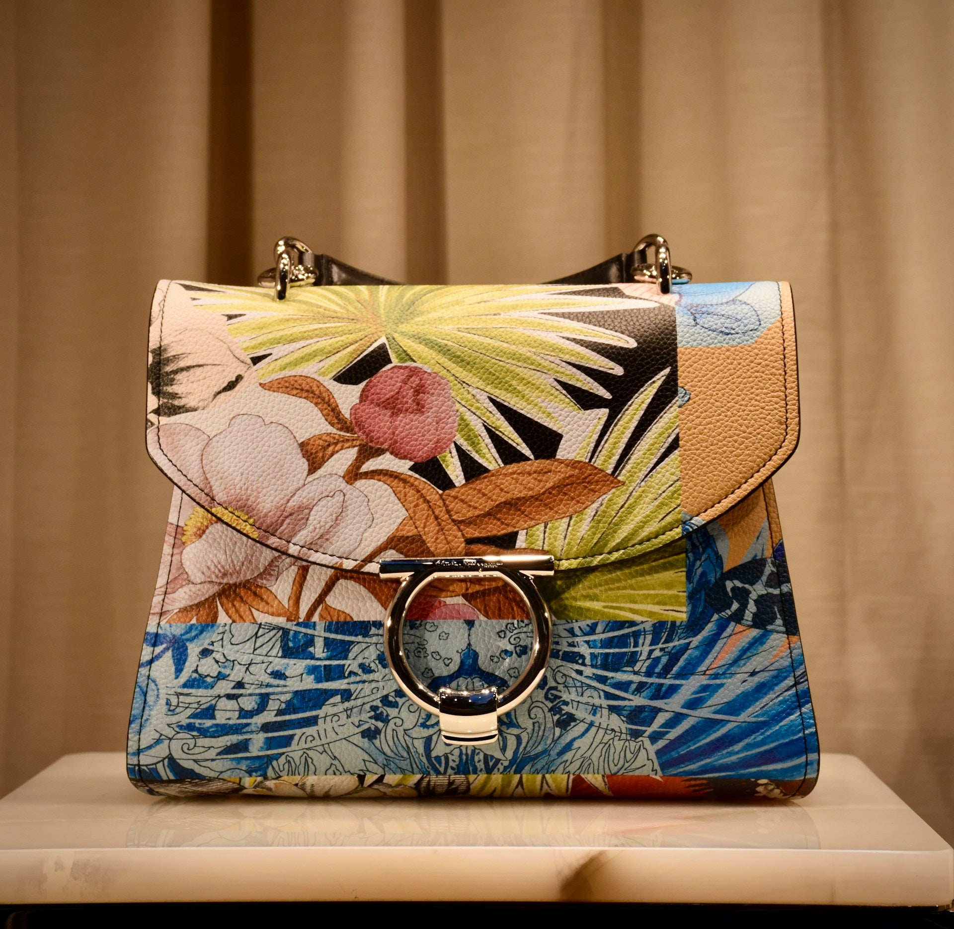 A patterned leather purse on a marble table.