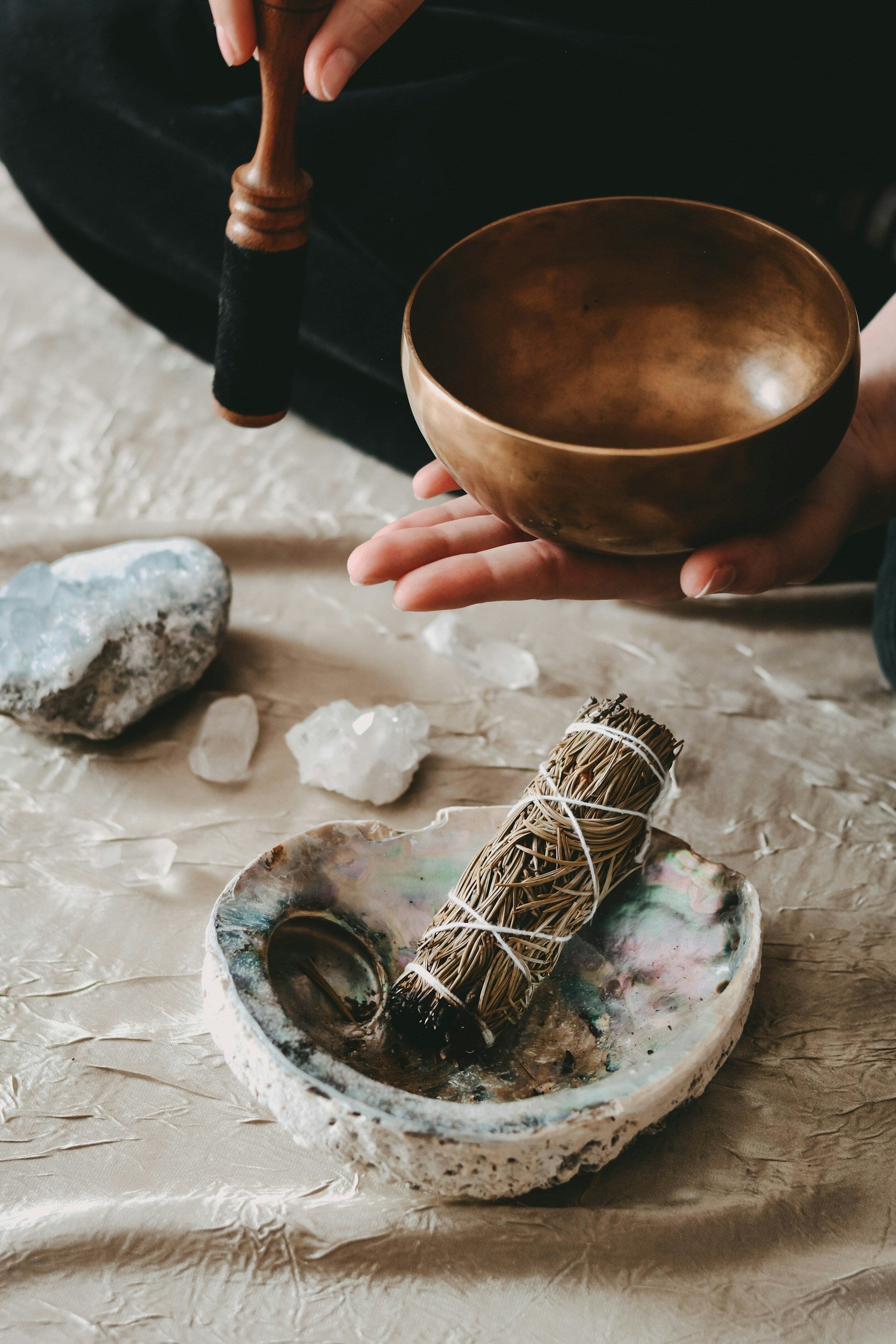 A sage stick inside a crystal bowl.