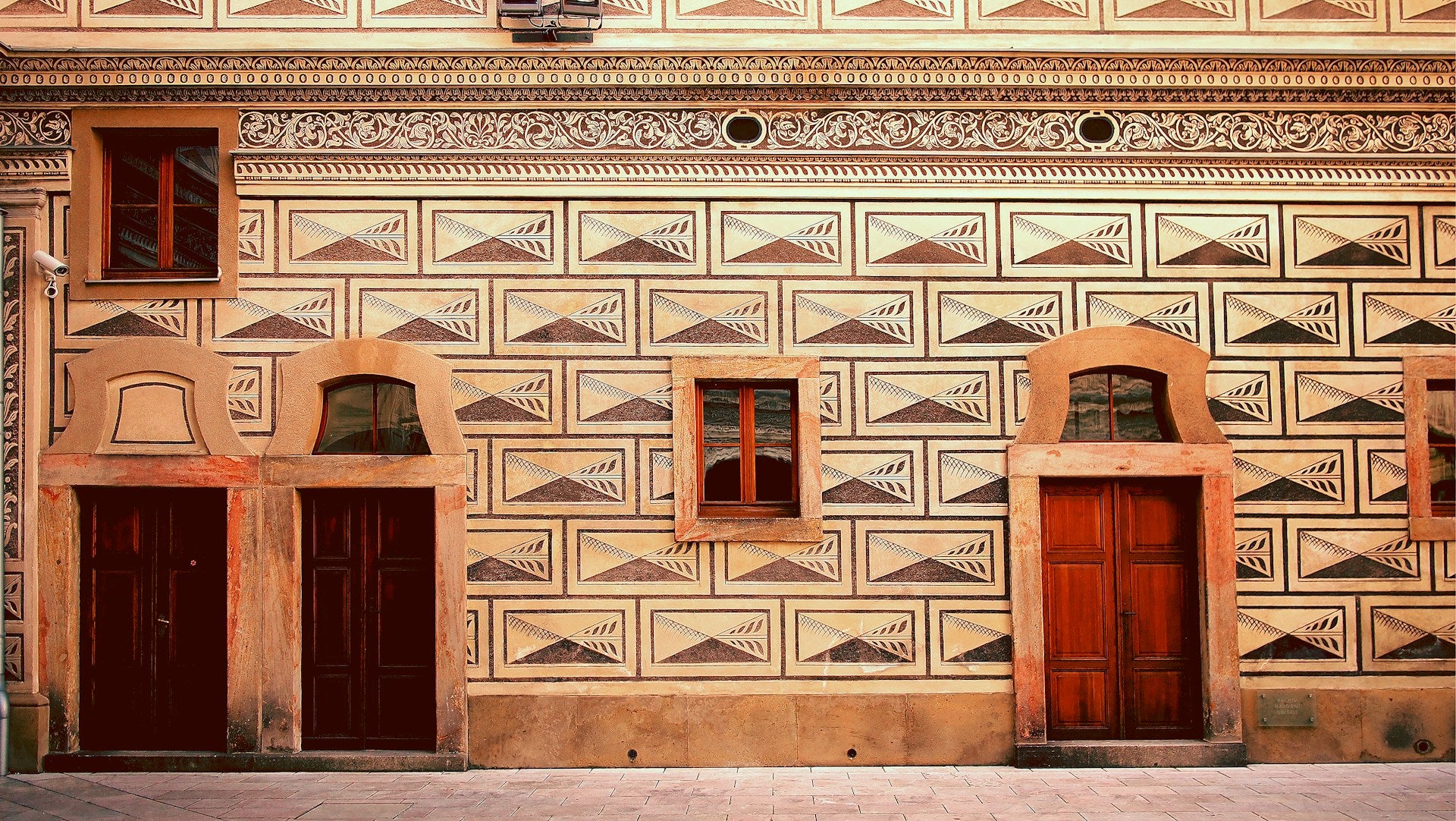 A building with geometric patterns and three doors.