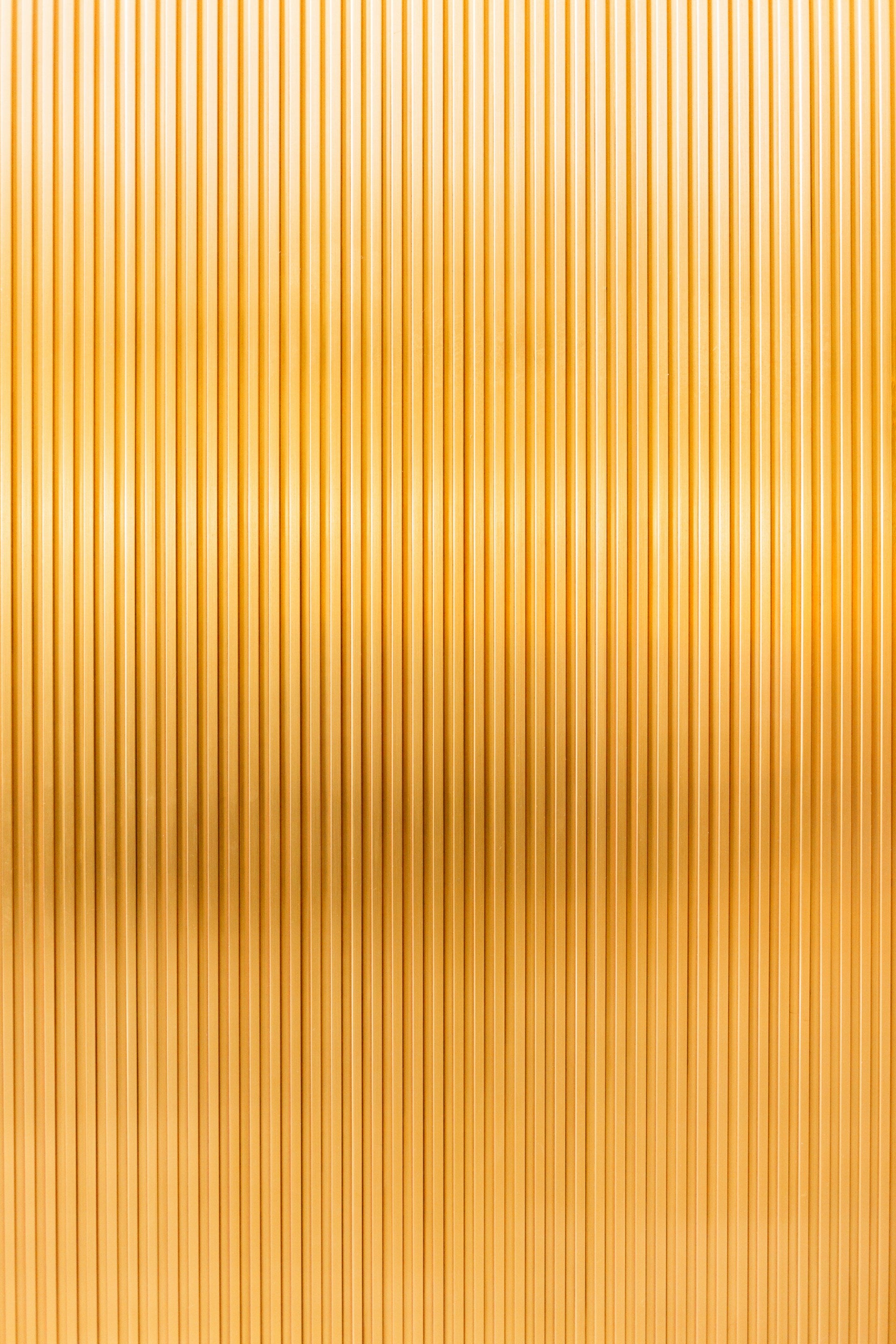 A gold metal surface with thin paneling.