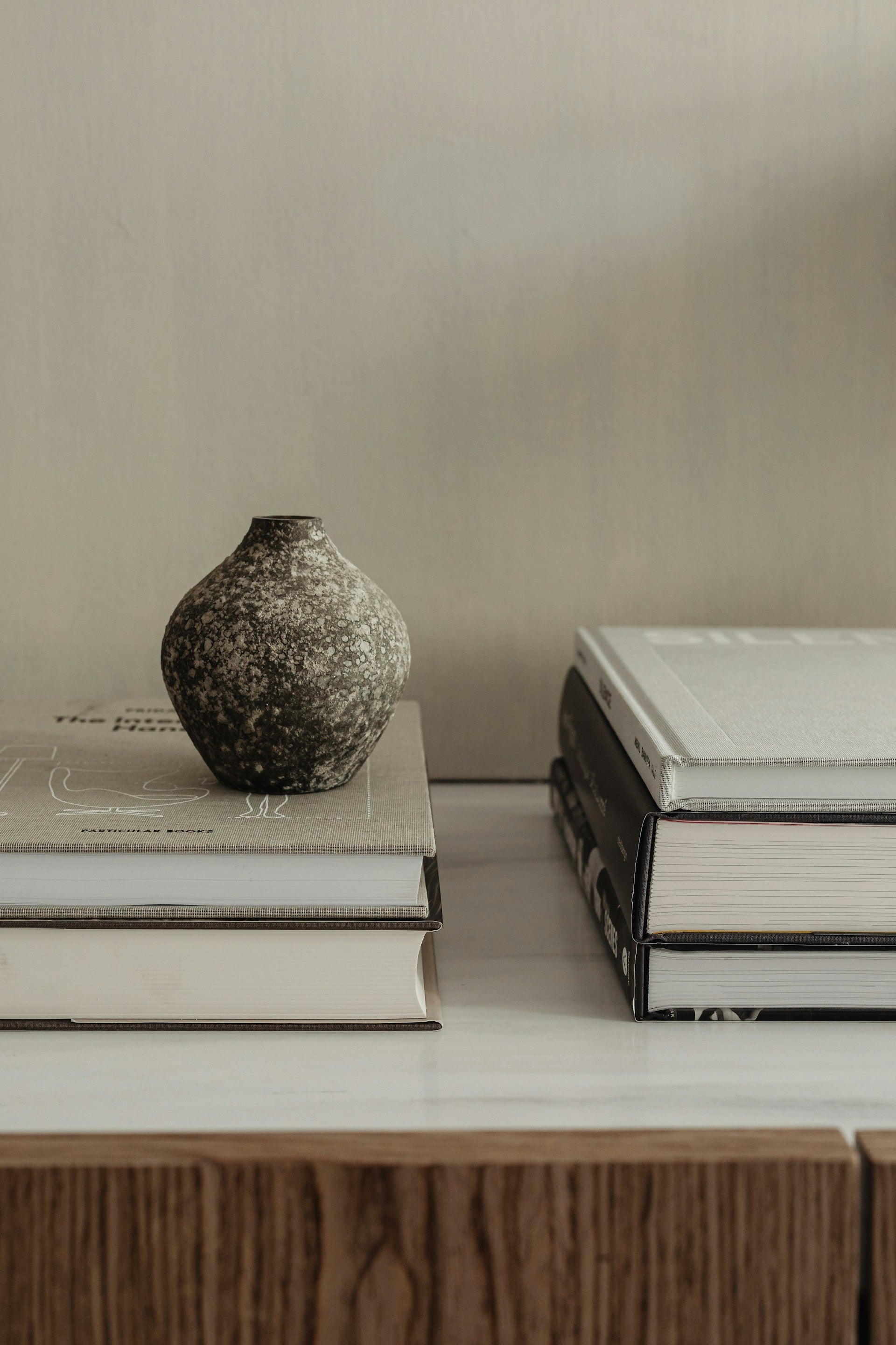 A vase sitting on top of a stack of books.