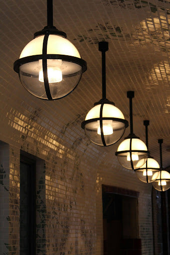 A row of round lights hanging from a tiled ceiling.