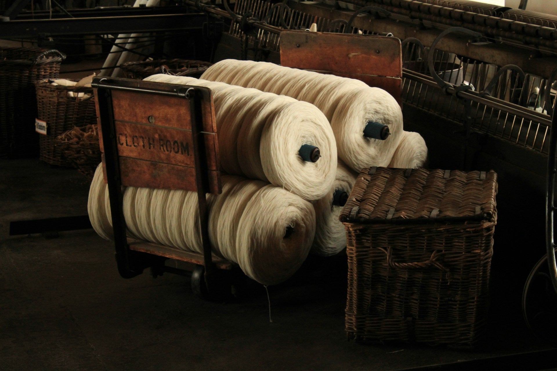 Rolls of string stacked on a wooden cart in a factory.