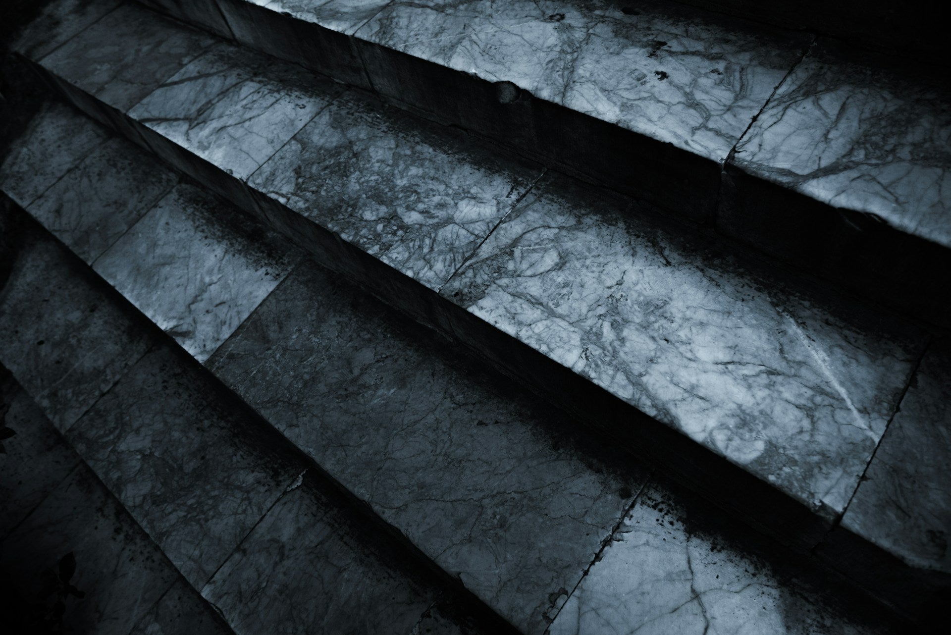 Black and grey stairs in a dark room.