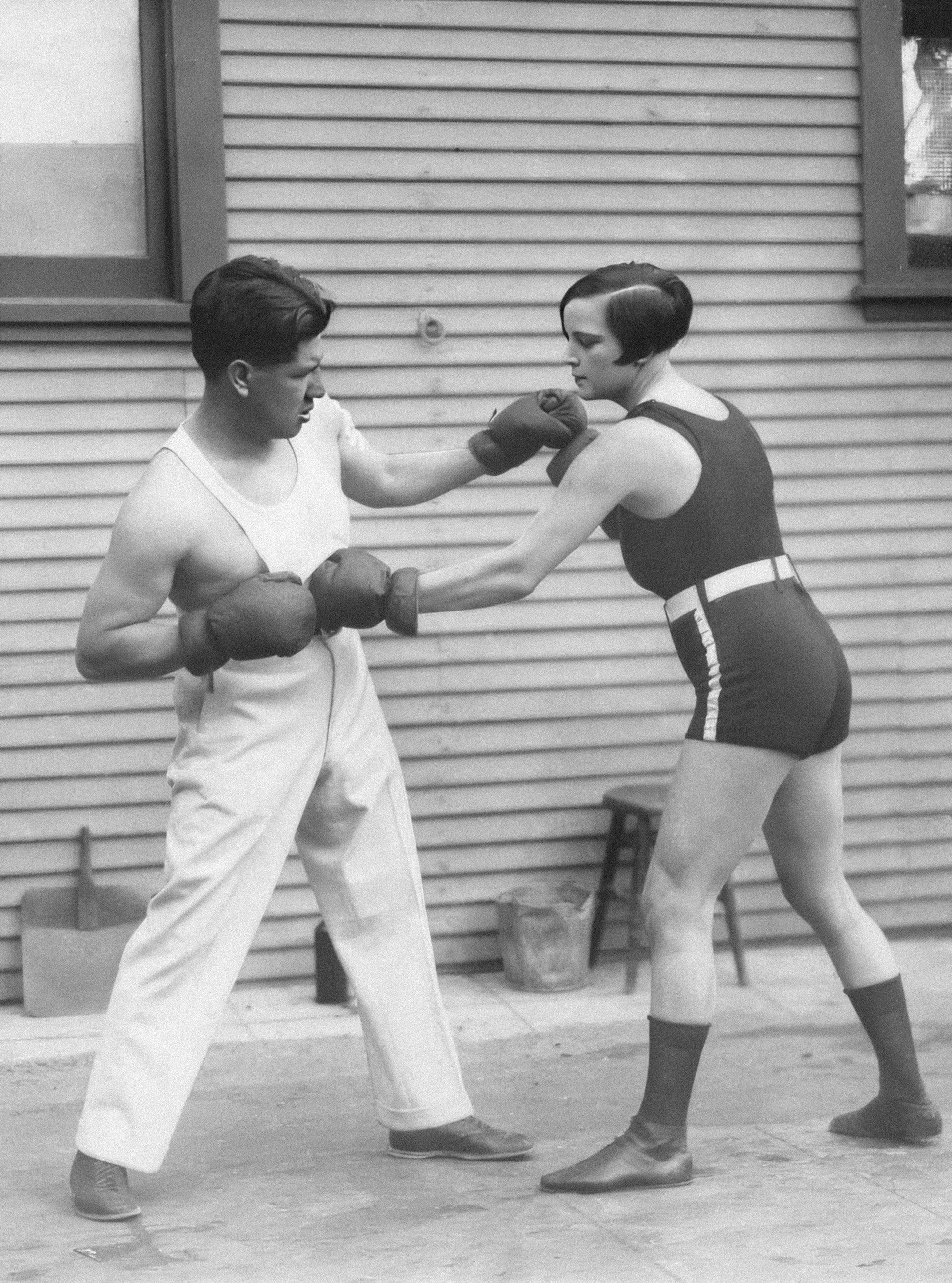 Two people boxing, in black and white.