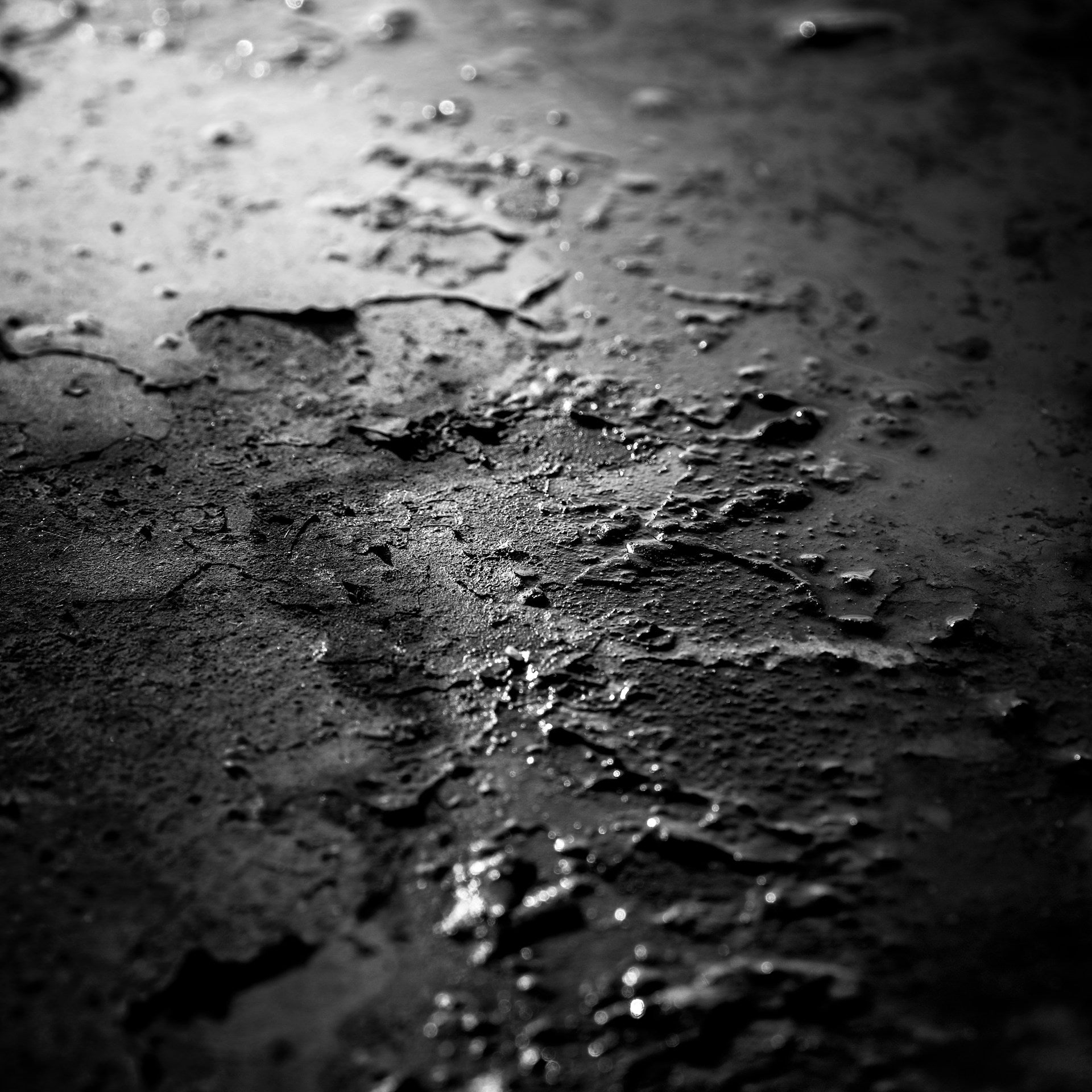A black and white photo of a rough concrete floor.