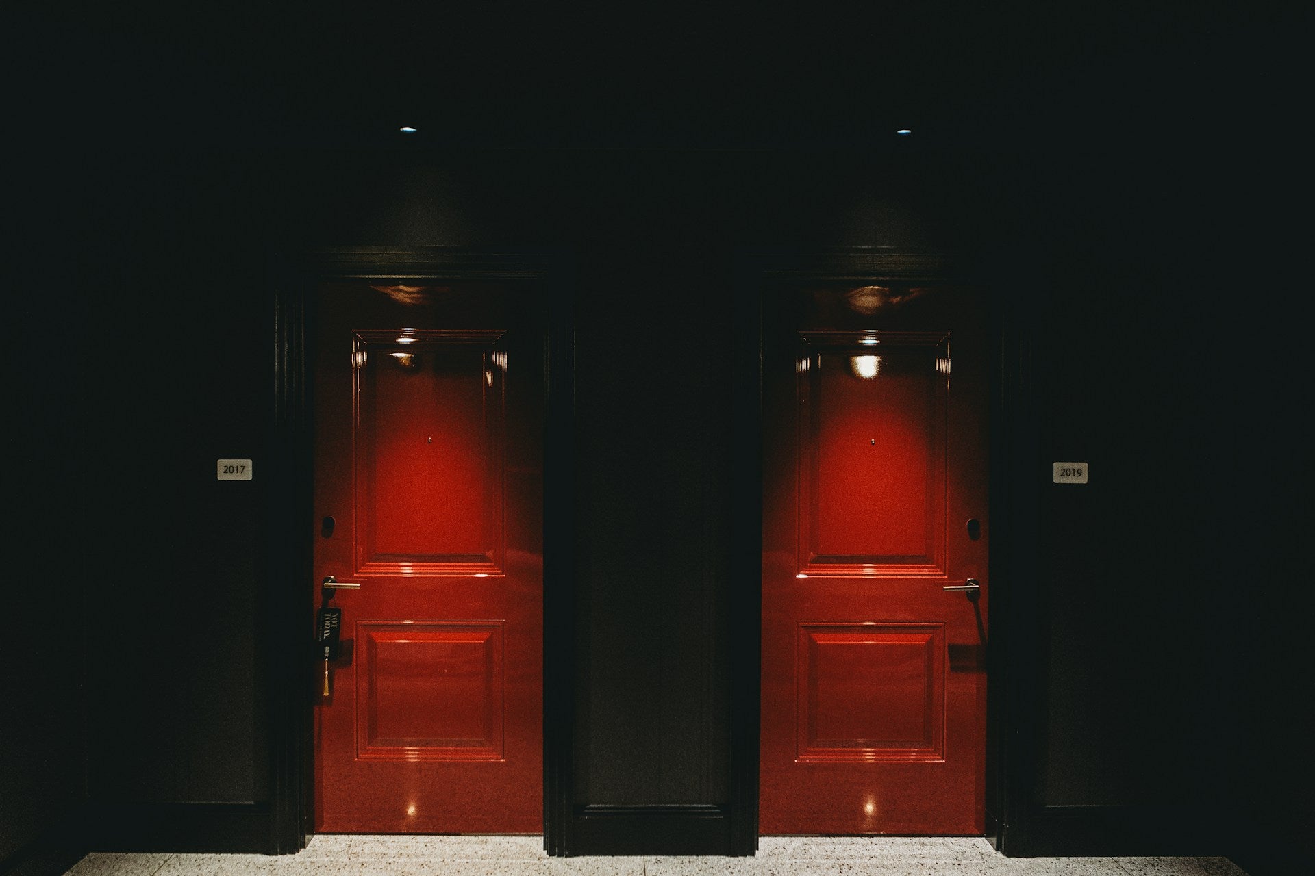 Two red doors in a dark room.