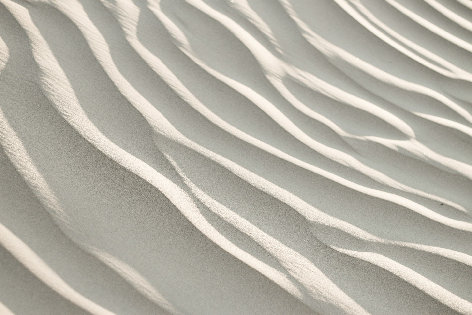 White sand dunes with ripples in the sand.