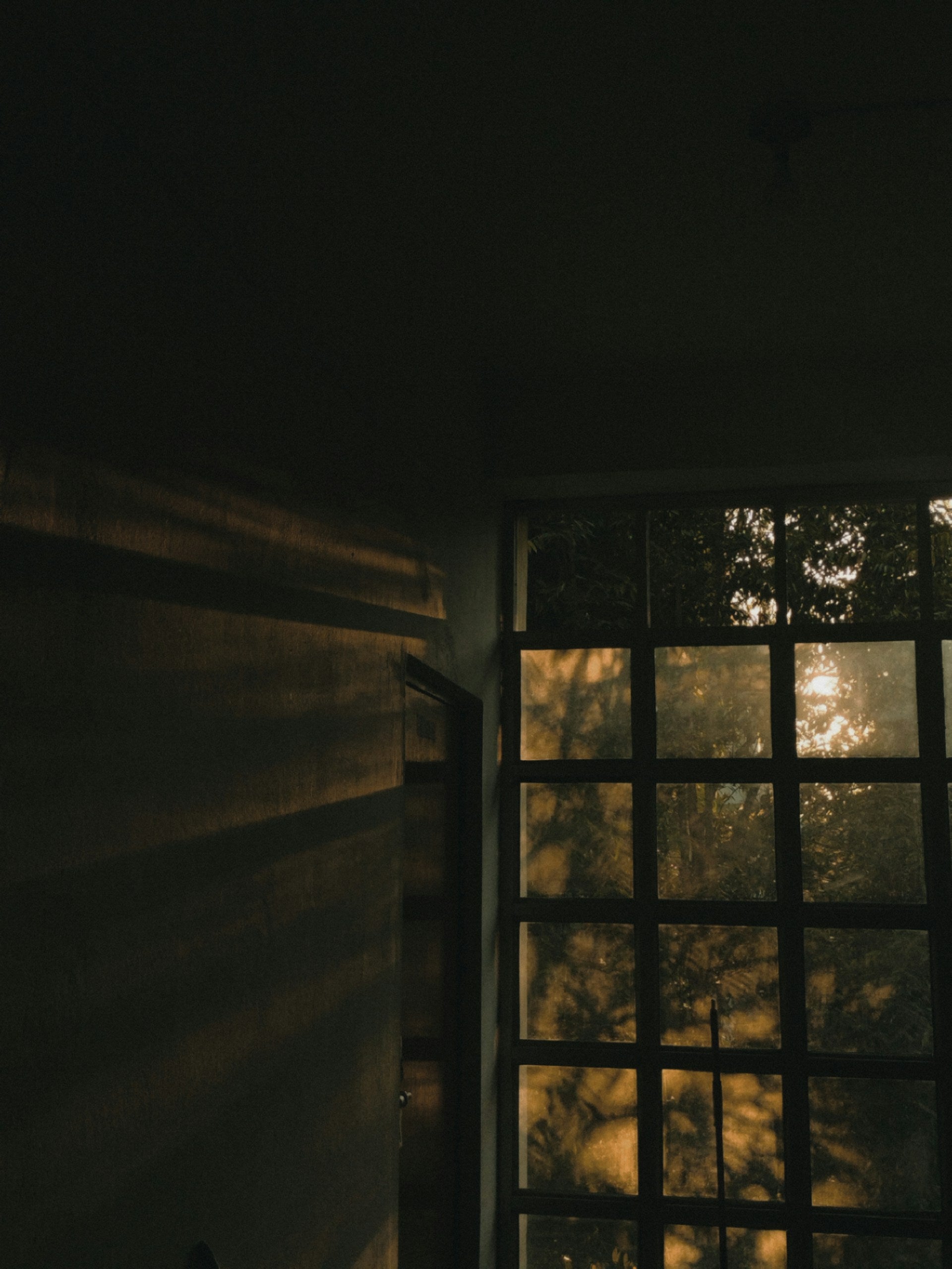 Sunlight shining through a window in a dark room.