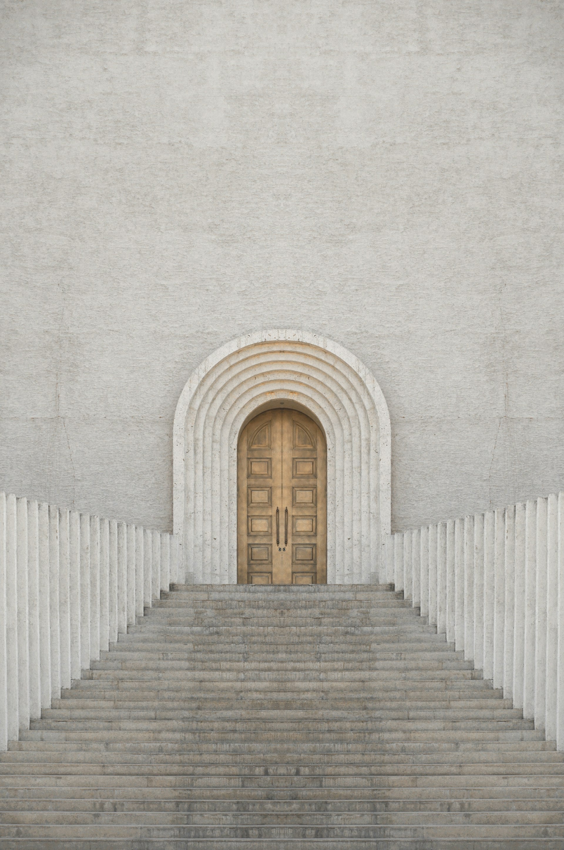 A white building with a wooden door and steps leading up to it.