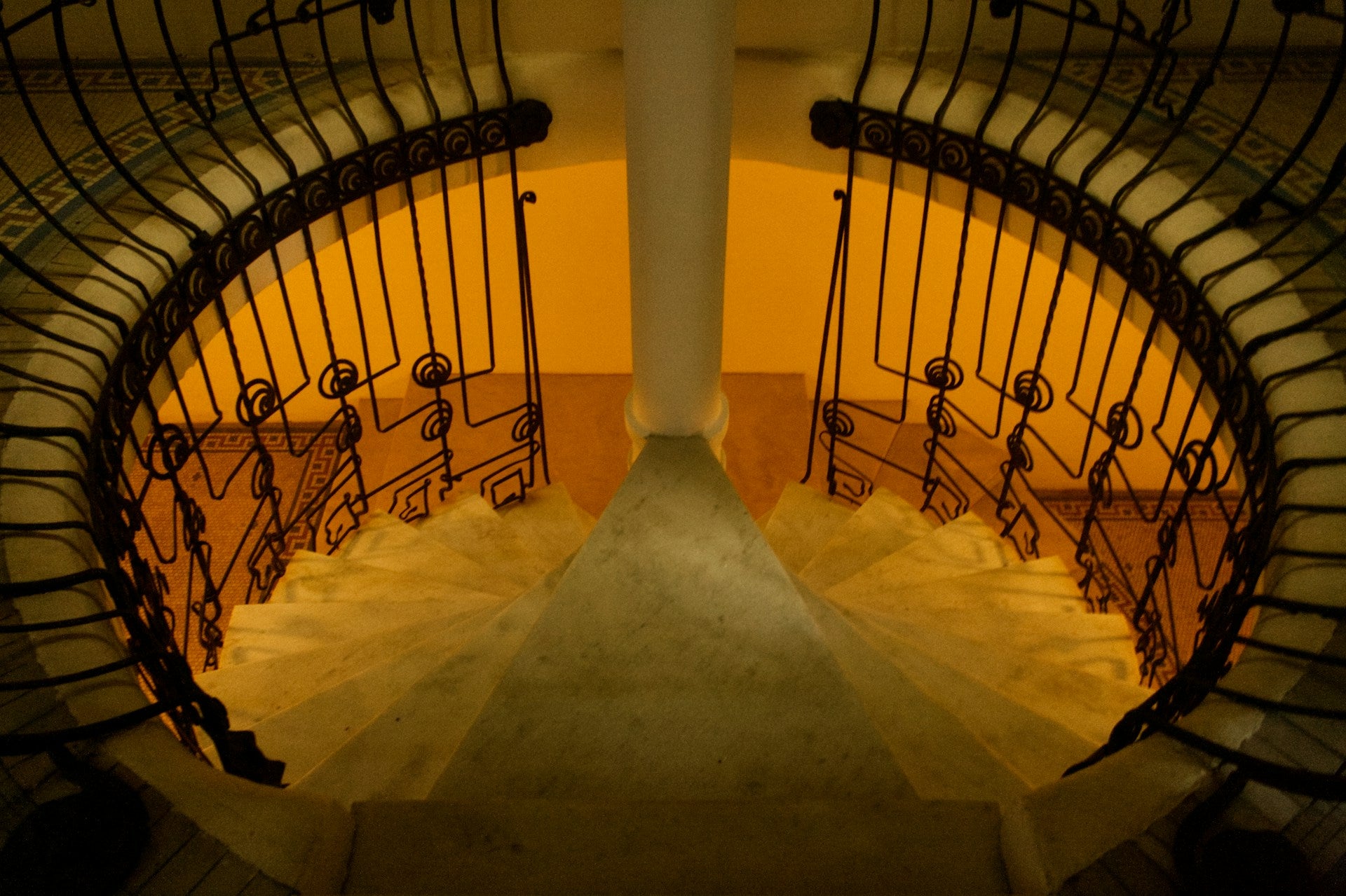 A spiral staircase in a building with golden light.