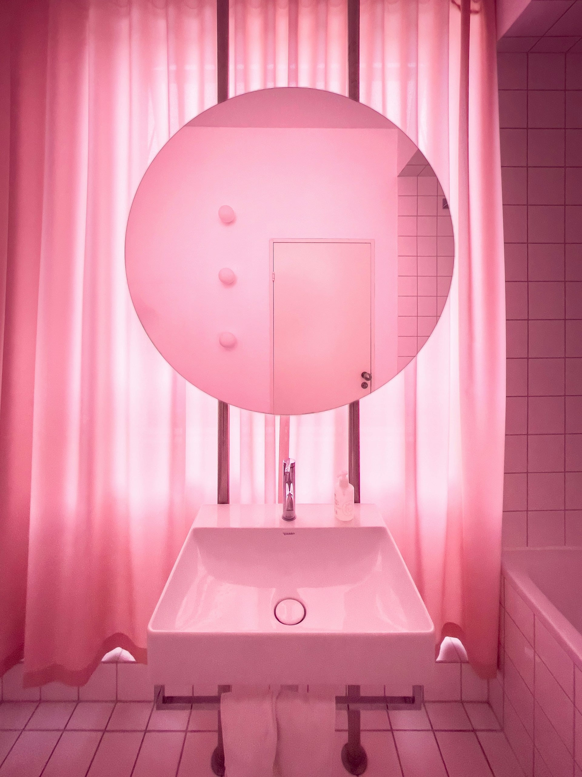 A pink bathroom with a white sink.