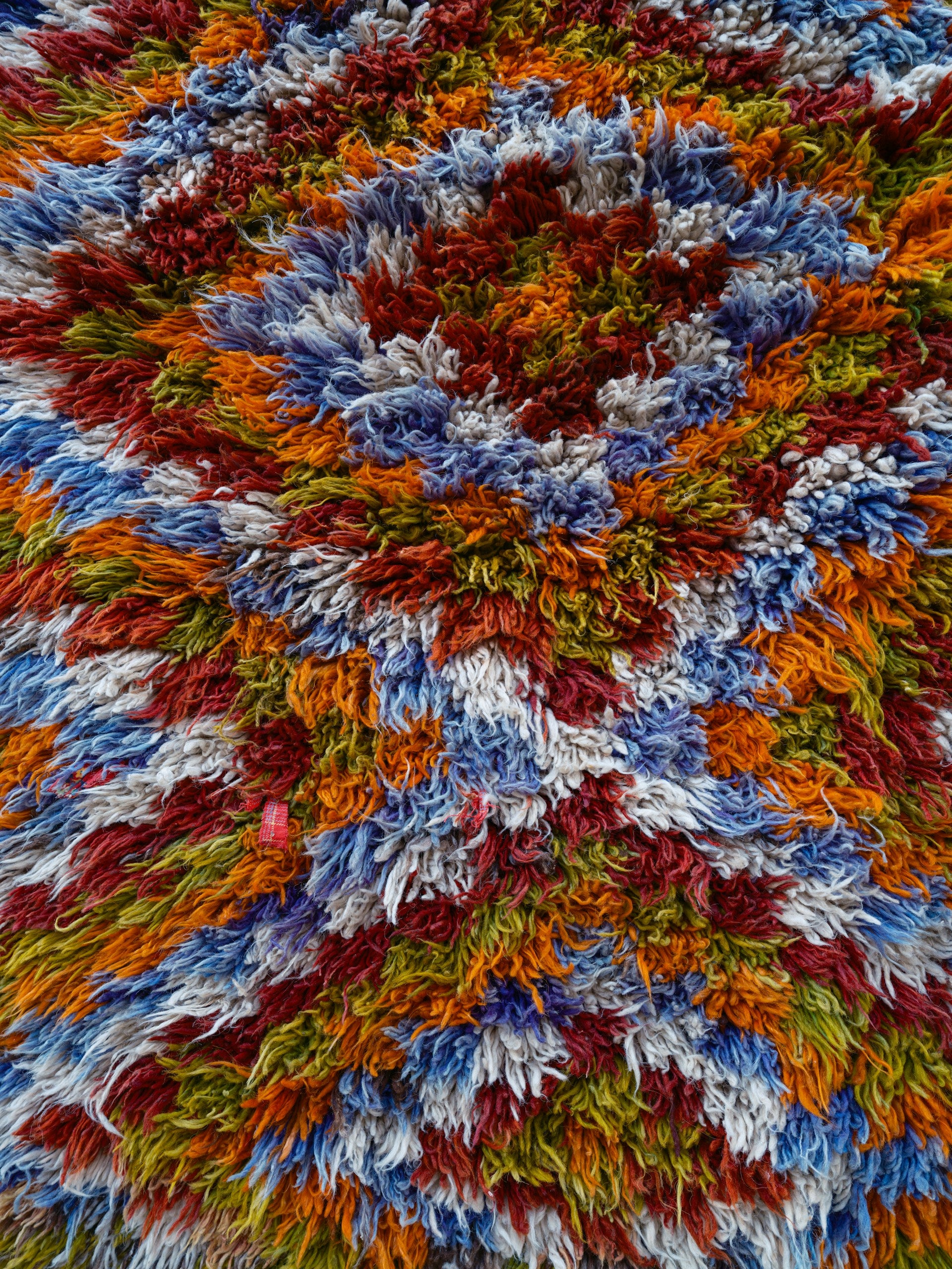 A close up of a colorful shaggy rug.