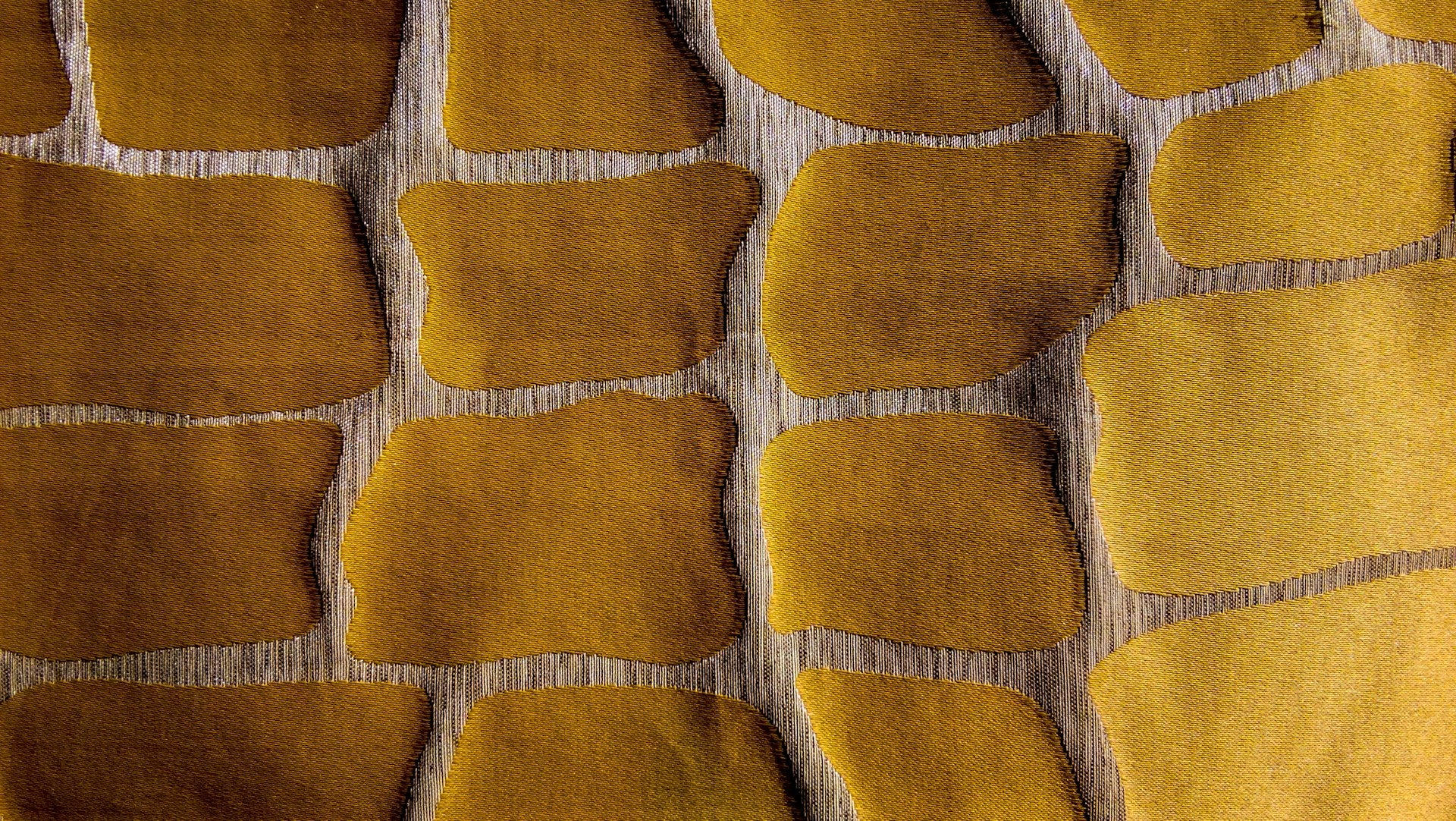 A beige piece of fabric with gold shapes on it. 