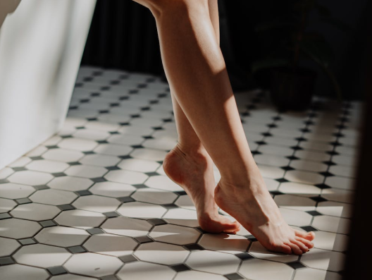 Bare feet touching black and white tile floor.