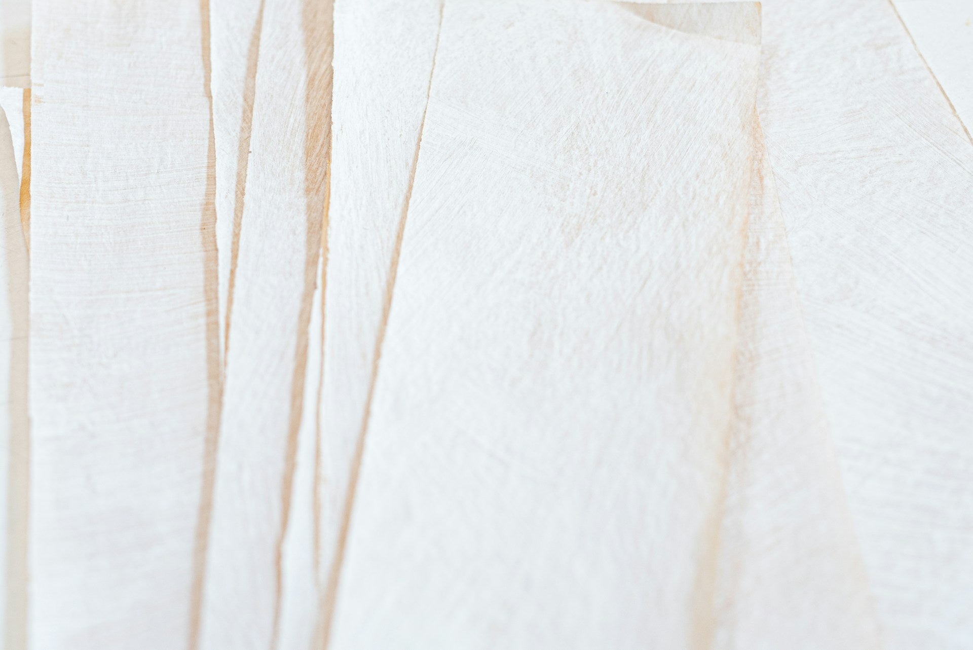 A piece of textured paper with beige organic stripes on it.