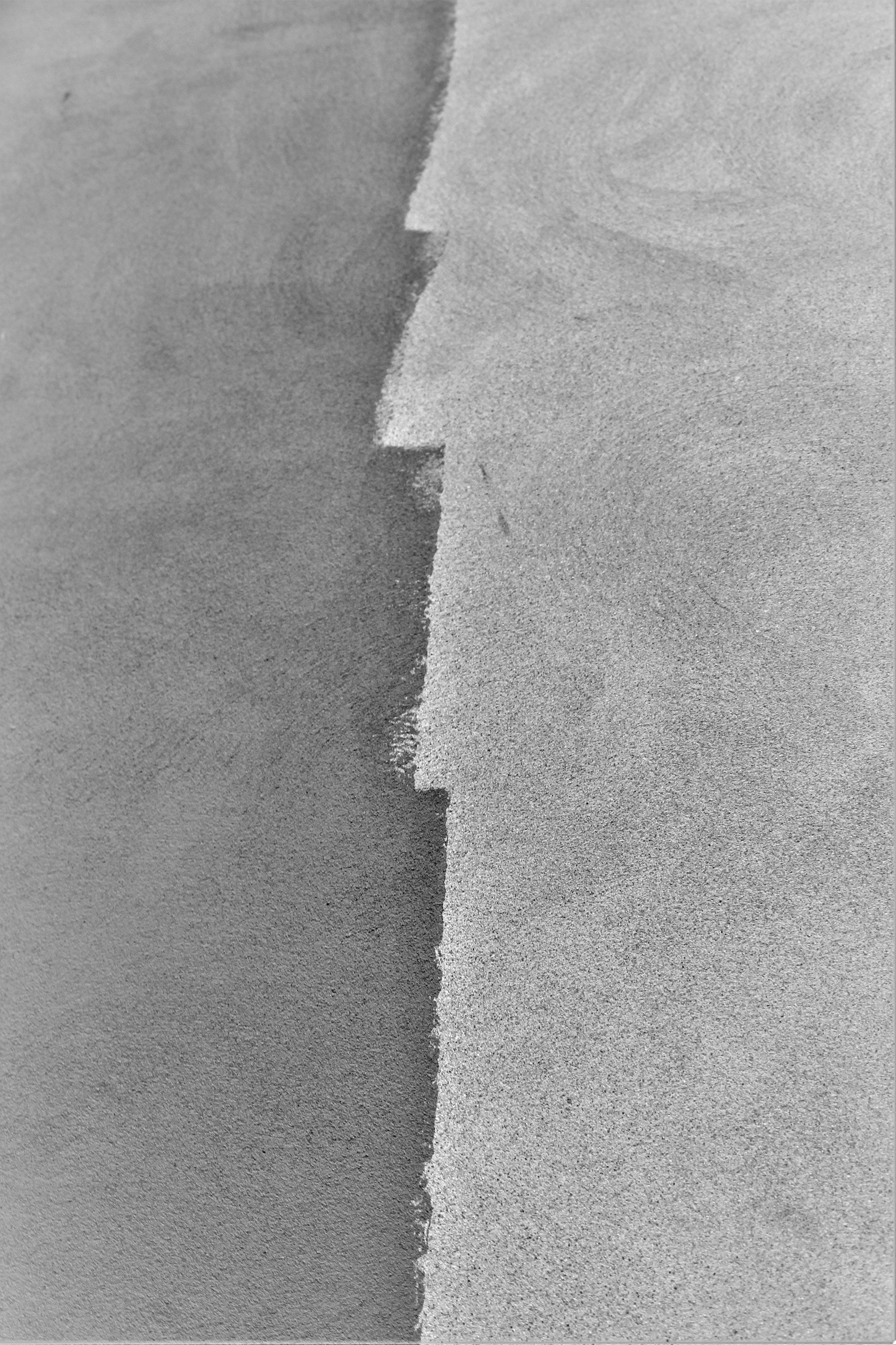 A black and white abstract photo of ripped paper.